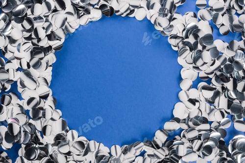 Preview: Top view of silver circle made of confetti on blue background
