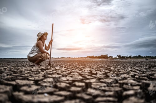 Preview: Woman Crouches With Staff on Cracked Earth