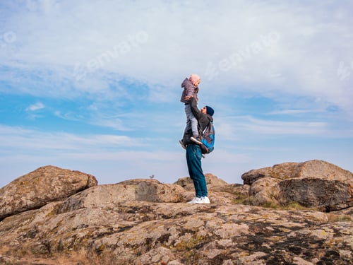 Preview: Travelers father and daughter walking climbing mountain summit cloudy sky back view together