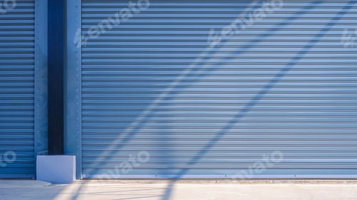 Preview: Light and shadow on automatic gray roller shutter entrance doors of industrial warehouse building