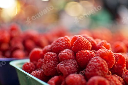 Preview: Selective focus shot of ripe raspberries with bokeh lights in background