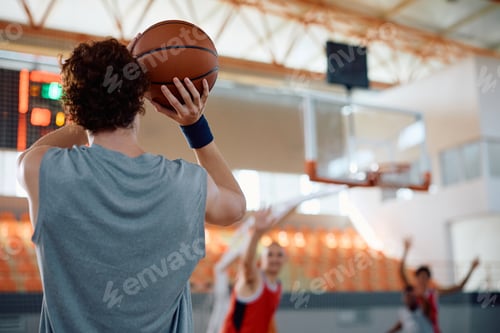 Preview: Rear view of basketball player shooting at the hoop.