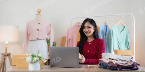 Preview: Asian SME business women use laptop computer checking customer order online shipping boxes at home