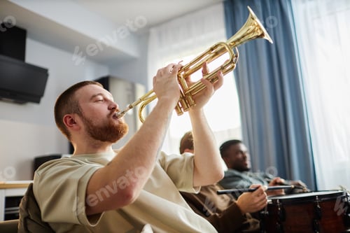 Preview: Man Playing Golden Trumpet Enjoying Sports Game on TV with Friends