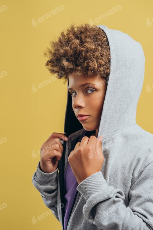 Preview: Handsome serious African American boy with curly hairstyle hood on the head looking at camera