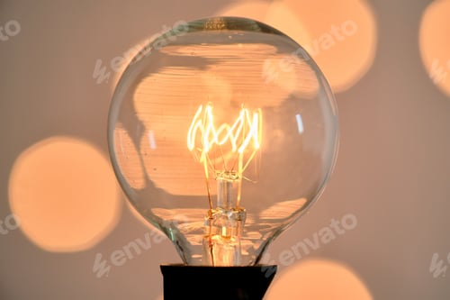 Preview: Incandescent light bulb with christmas round bokeh.