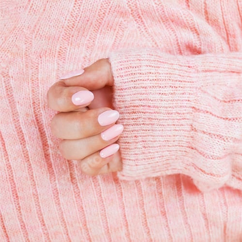 Preview: pink manicure on the texture of a pink sweater, hand care, pastel colors of manicure,