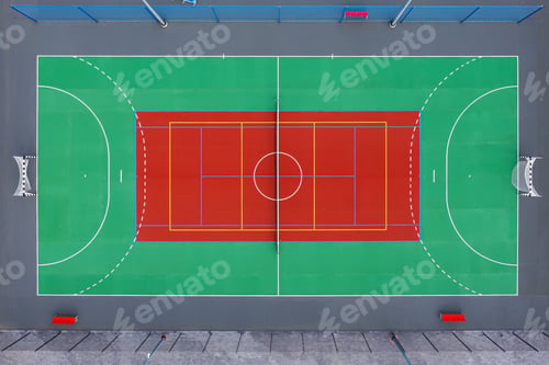 Preview: Aerial view of a vibrant basketball court with colorful markings in an urban setting