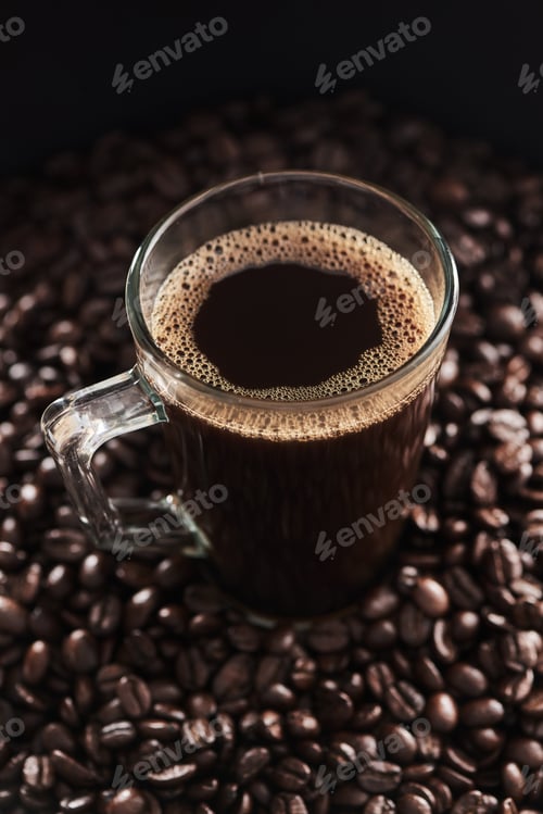 Preview: Closeup shot of a cup of black coffee surrounded by coffee beans