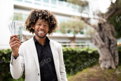 Preview: Cheerful black middle aged businessman showing a lot of money cash, recommend investment, standing
