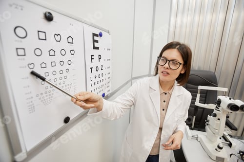 Preview: Female Ophthalmologist Pointing at Eye Chart