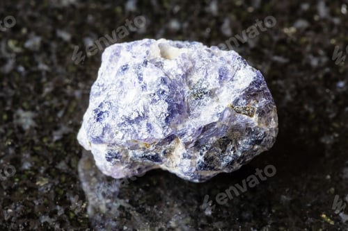 Preview: sample of raw cordierite rock on black granite