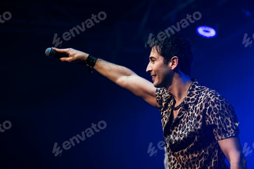 Preview: Singing artist performing before the audience at a live concert.