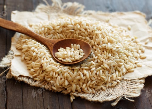 Preview: Pile of Brown rice with a wooden spoon
