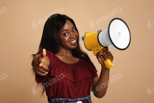 Preview: Attractive afro-american lady with loudspeaker pointing at camera
