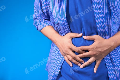 Preview: young man suffering stomach pain sitting on sofa