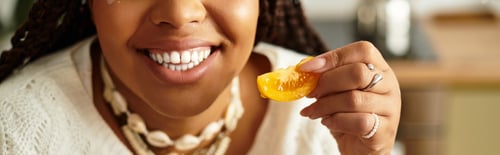Preview: Joyful cooking moment of a young african american woman preparing a fresh salad at home