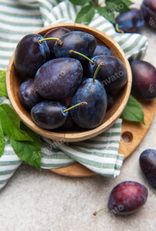 Preview: Fresh ripe plums filling a wooden bowl