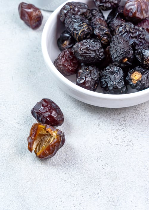 Preview: Raw Organic Arabic Dates, Ajwa Dates on light gray background. Ramadan Kareem. Close up.