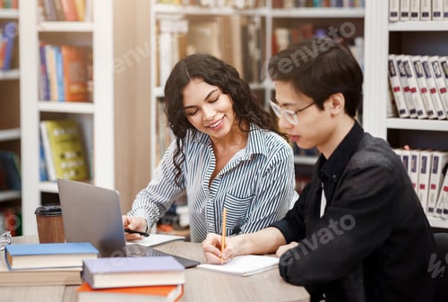 Preview: Latin counselor sitting and looking at student's work