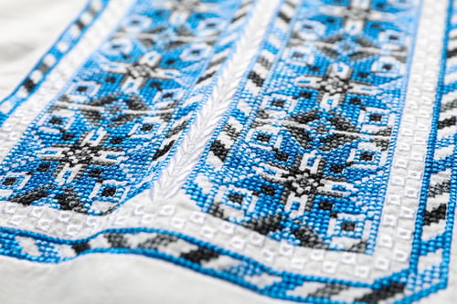 Preview: Beautiful light blue Ukrainian national embroidery on white fabric, closeup