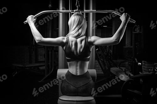 Preview: Charming Blonde Does Exercises For The Back In The Gym. Neck Pull For The Head. The Concept Of