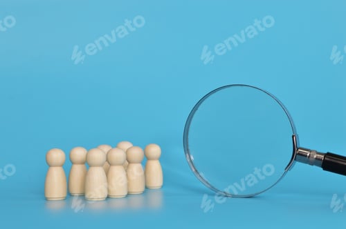 Preview: Magnifying glass is looking at the wooden figures of people