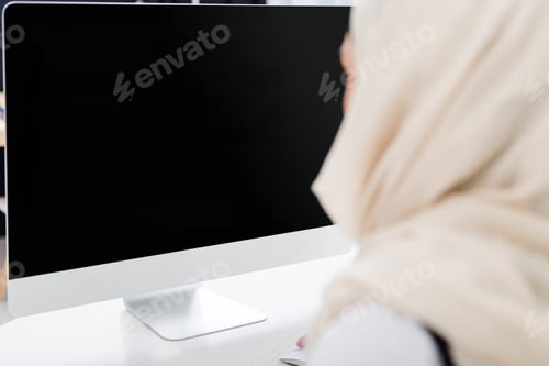 Preview: partial view of businesswoman sitting at blank computer screen