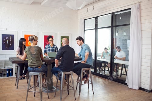 Preview: Coworkers talking in office, other working in background