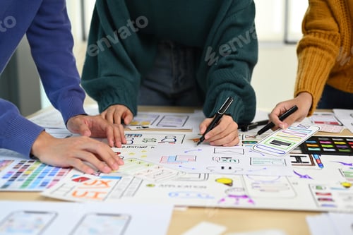 Preview: Cropped image of web developer team collaborating and planning template layout.