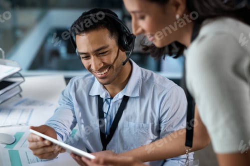 Preview: Shot of a young man and woman using a digital tablet while working in a call centre