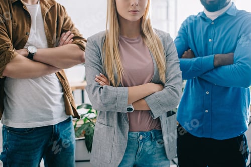 Preview: cropped shot of three business colleagues with crossed arms in modern office