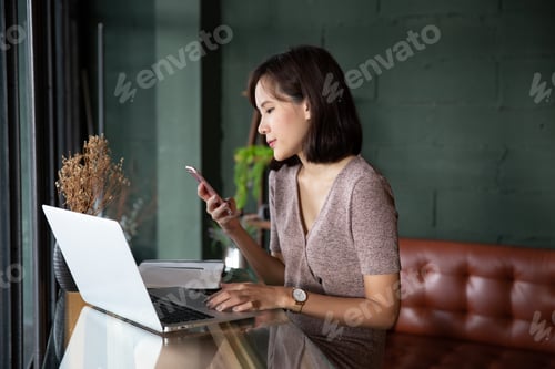 Preview: Young beautiful asian woman working in loft cafe or office
