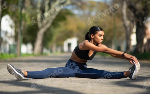 Preview: Shot of a sporty young woman stretching her legs while exercising outdoors