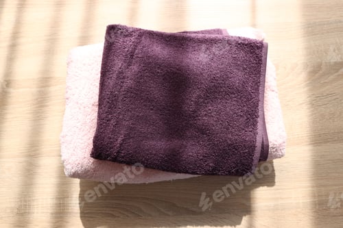Preview: Stack of soft towels on wooden table, above view