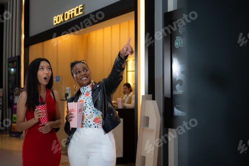 Preview: Both of young woman stand and watch the movie program to watch today.
