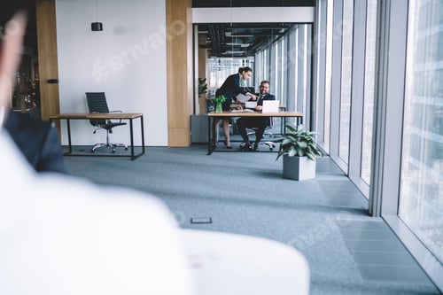Preview: Male and female employees at table with laptop