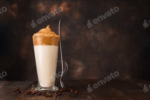 Preview: A long glass with very trendy whipped Dalgona coffee against dark background