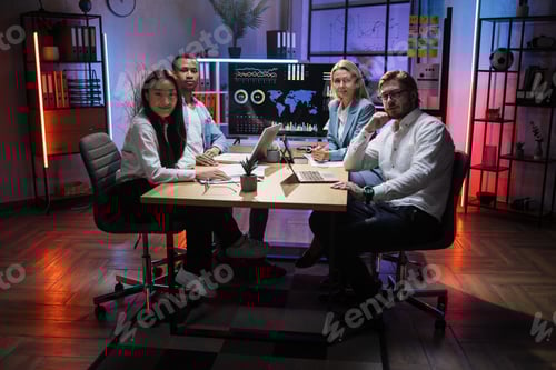 Preview: Diverse economists sitting at desk with modern gadegts