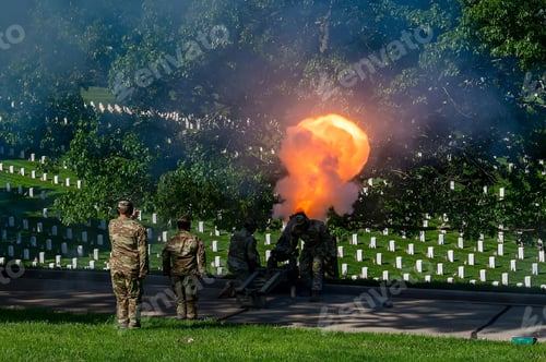 Preview: Military personnel conduct a ceremonial cannon fire at a cemetery surrounded by gravestones