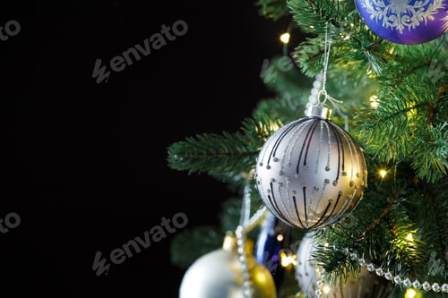 Preview: Christmas fir branches with decorations on a black background, copy space.