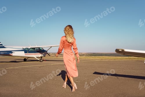 Preview: Woman in Peach Dress on Airport Tarmac