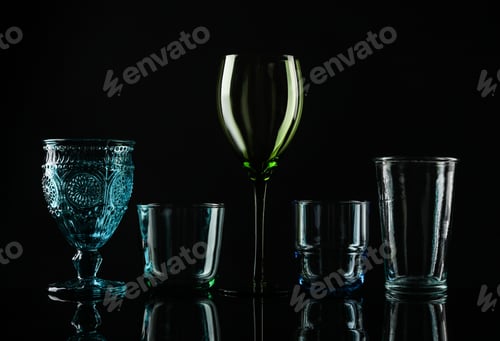 Preview: Set of different colorful empty glasses on black background