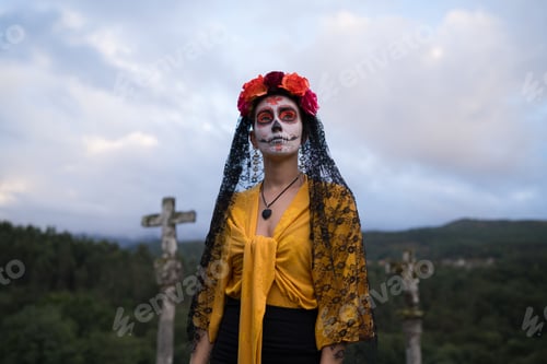 Preview: Woman celebrating day of the dead in cemetery with cloudy sky