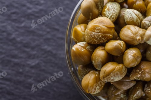 Preview: pickled capers on a dark stone background