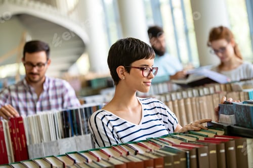 Preview: Happy group of students studying and working together in a college library