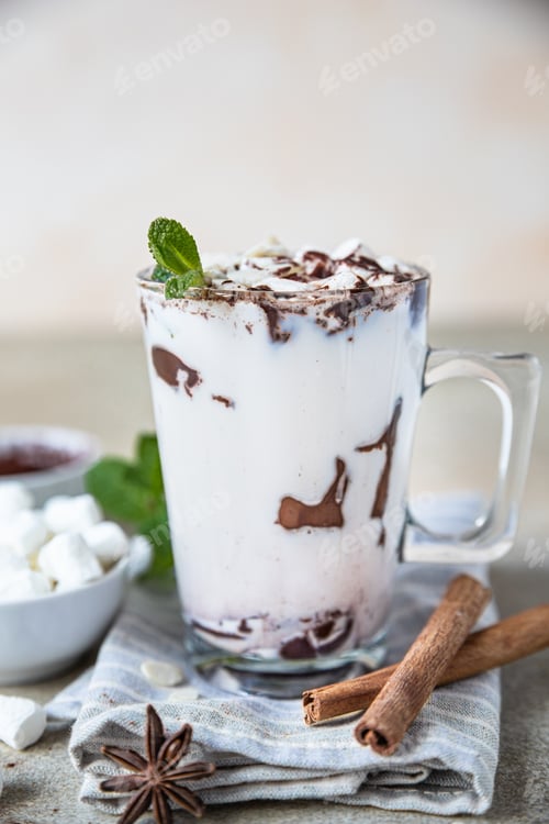 Preview: Hot chocolate or cocoa in glass cup with marshmallow, cinnamon and mint