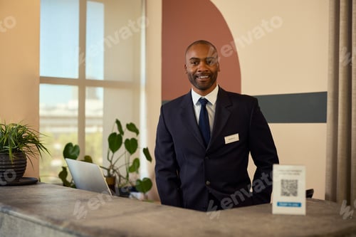 Preview: Confident black receptionist at front desk smiling