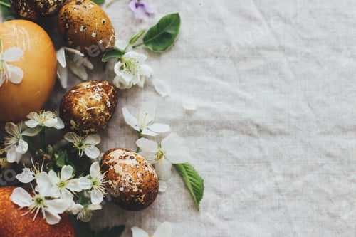 Preview: Easter eggs with spring flowers on rustic linen, flat lay with space for text. Aesthetic card