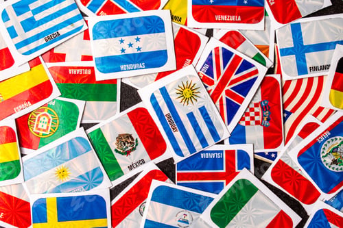 Preview: Top view of various international flag stickers scattered on a surface